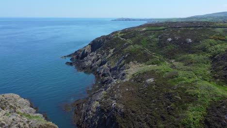 Peaceful-Amlwch-Anglesey-North-Wales-rugged-mountain-coastal-walk-aerial-view-wide-orbit-left-descend