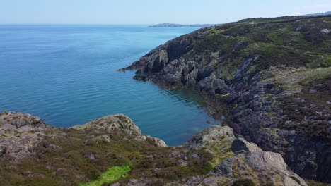 Dramatic-Amlwch-Anglesey-North-Wales-rugged-mountain-coastal-walk-aerial-view-orbit-right