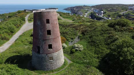Amlwch-port-red-brick-disused-abandoned-windmill-aerial-view-North-Anglesey-Wales-close-pull-away