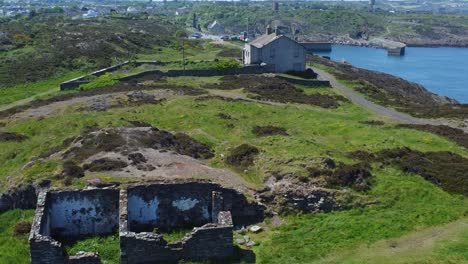 Abandoned-Amlwch-coastal-countryside-mountain-house-aerial-view-overlooking-Anglesey-harbour-lowering-left