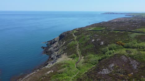 Peaceful-Amlwch-Anglesey-North-Wales-rugged-mountain-coastal-walk-aerial-view-slow-descend-left