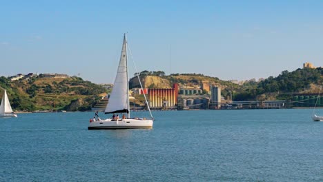 Segelboote-überqueren-Den-Wurzelpfad-Am-Sonnigen-Tag-Der-Sommersaison-Des-Tagus-In-Lissabon-Portugal-In-Der-Nähe-Der-Brücke-Des-25.-April