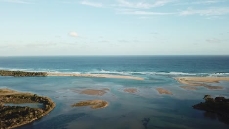 Drone-flight-over-islands-in-the-Mallacoota-Inlet-and-mouth-of-the-Wallagaraugh-River-at-sunset,-eastern-Victoria,-Australia,-December-2020
