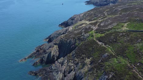 Peaceful-Amlwch-Anglesey-North-Wales-rugged-mountain-coastal-walk-aerial-view-orbit-right
