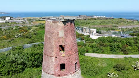Amlwch-port-red-brick-disused-abandoned-windmill-aerial-view-North-Anglesey-Wales-close-orbiting-right