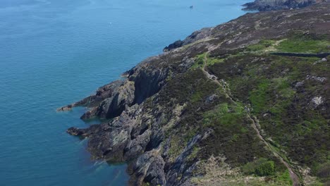 Peaceful-Amlwch-Anglesey-North-Wales-rugged-mountain-coastal-walk-aerial-view-descend-tilt-up