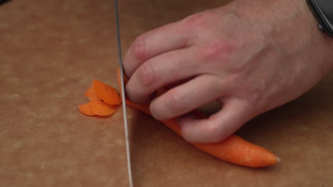 Hands-Cutting-Carrot-Into-Thin-Slice