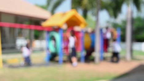 School-children-playing-at-a-playground-defocused,-captured-during-a-sunny-day