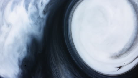Abstract-white-paint-swirl-slowly-pushing-back-black-cloudy-shape-ink-liquid