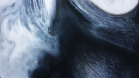 Abstract-paint-swirl-moving-across-mixed-black-and-white-liquid-in-slow-motion