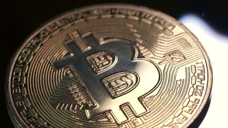 4K-Kryptomünze-In-Bitcoin-Währung,-Die-Sich-Langsam-Im-Uhrzeigersinn-Mit-Reflektierendem-Licht-Vor-Schwarzem-Hintergrund-Dreht
