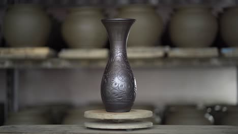 Final-product-pottery-on-potter's-wheel-view,-toned-cinematic,-craft-factory-authentic,-black-pottery-specific