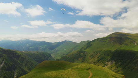 Breite-Drohnenaufnahme-Eines-Gleitschirms-Im-Kaukasus-Gebirge-In-Gudauri,-Georgien