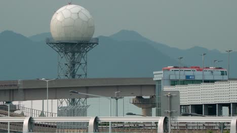 Bus-Traveling-In-The-Overpass-At-The-Busan-Airport-With-A-Spherical-Radar-Antenna-On-The-Backdrop