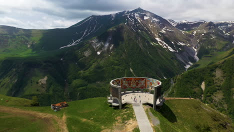 Cinematic-drone-shot-of-the-Arch-of-Friendship-Of-Peoples-and-the-Caucasus-mountains-in-Gudauri-Georgia