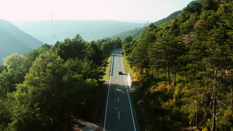 Blue-Car-Passing-Through-Mountain-Road-In-Rural-Countryside