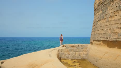 Mujer-Mochilera-Haciendo-Senderismo-Y-Visitando-Las-Ruinas-De-Qolla-L-bajda-En-La-Isla-De-Gozo,-Malta