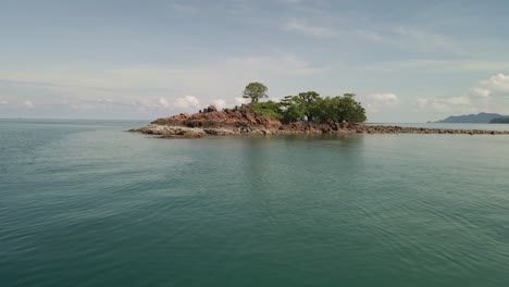 4K-Luftdrohnenaufnahmen,-Die-über-Wasser-Und-Eine-Isolierte-Insel-Mit-Bäumen-In-Thailand-Fliegen