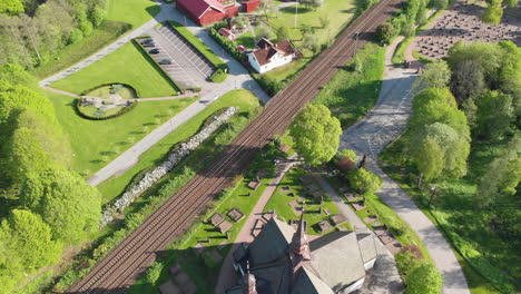 4K-Aerial-Footage-Overhead-Looking-Down-at-Railway-and-Church-in-the-Town-of-Lerum,Vastra-Gotaland,-Sweden