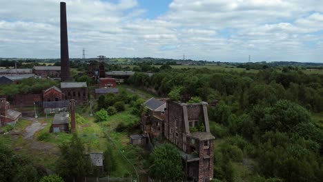 Abandoned-old-overgrown-coal-mine-industrial-museum-buildings-aerial-view-fly-forwards-descent