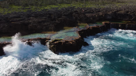 Aerial:-New-Caledonia-Cap-des-pins-on-island-of-Lifou,-rugged-coastal-rock-pools