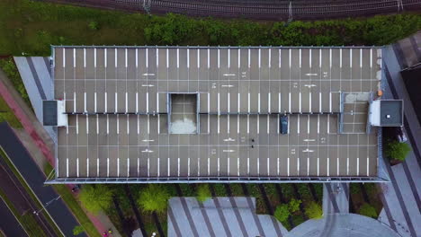 Two-Persons-Walk-Towards-Car-Parked-On-Building-Rooftop-In-Bremen,-Germany
