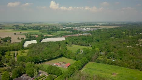 Aerial-drone-view-of-the-beautiful-flat-landscape-of-the-suburban-area-in-the-Netherlands-and-trains-are-passing-by
