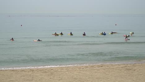 Turistas-Remando-Con-Sus-Tablas-De-Surf-En-La-Playa-De-Songjeong-En-Busan,-Corea-Del-Sur