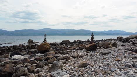 Balanced-spirituality-meditation-pebbles-piled-on-alien-rocky-mountain-range-beach-coastline-push-in-between-towers