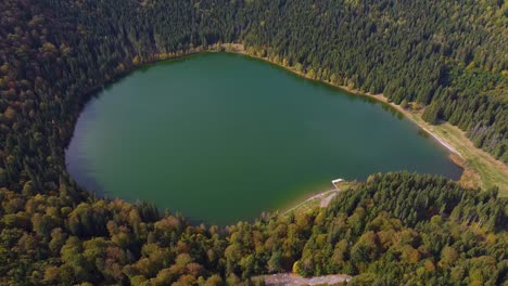 Top-view-aerial-flight-over-small-lake-of-round-shape