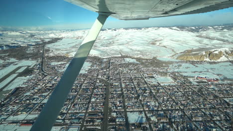 Flying-in-Small-Airplane-Above-Snow-Capped-Gunnison-Town,-Colorado-USA,-Getaway-to-Crested-Butte-Mountain-Resort-and-Maroon-Bells-Peaks