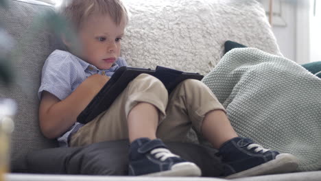 Junge-Lernt-Neue-Dinge-Auf-Dem-Smartphone,-Während-Er-Auf-Der-Couch-Sitzt