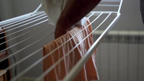 Man-hanging-wet-towel-in-metal-clothesline