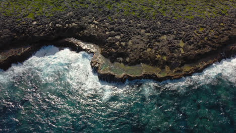 Aerial-view-of-Lifou-island-in-New-Caledonia,-rugged-Pacific-coastline-cliffs