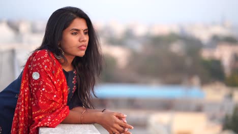 Young-Indian-woman-alone-on-roof-top-with-sky-and-trees-background-4k