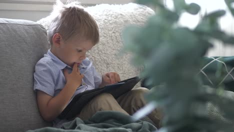 Young-stylish-boy-learning-to-use-tablet-computer,-indoor-static-view