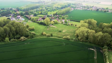 Flying-over-green-fields-towards-a-small-village
