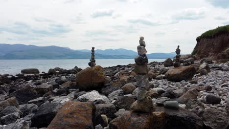 Balanced-spirituality-meditation-pebbles-piled-on-alien-rocky-mountain-range-beach-coastline-close-right-orbit