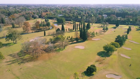AERIAL---Sand-traps-and-the-green-at-a-golf-club,-wide-shot-forward