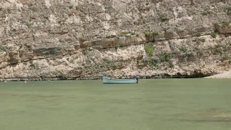 Un-Barco-Navegando-En-El-Mar-Mediterráneo,-Cerca-De-La-Costa-En-Gozo,-Malta