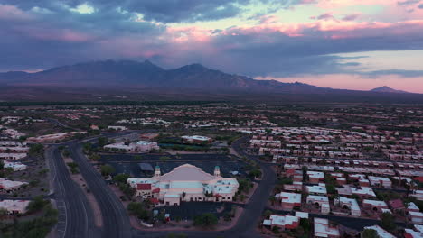 Drohne-Kreist-über-Der-Gemeinde-Der-Wüstenhügel-Im-Grünen-Tal,-Arizona-Bei-Intensivem-Sonnenuntergang-Mit-Wolken---Luftaufnahme
