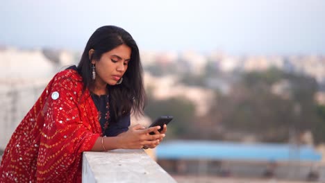 Woman-of-Indian-ethnicity-looking-at-mobile-phone-with-a-worried-face-expression-in-4k