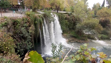 Shot-of-Duden-waterfall-in-Antalya,-Turkey-from-behind-leaves-and-plants
