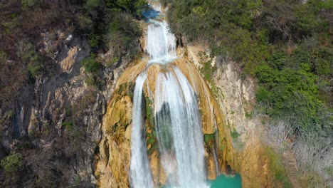 Beautiful-waterfalls-cascading-down-rocky-rainforest-mountainside,-4K-aerial