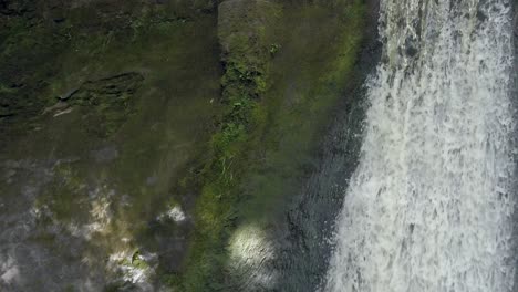 Peaceful-woodland-forest-splashing-waterfall-slow-motion-flowing-paradise-wilderness-closeup-rising-tilt-up