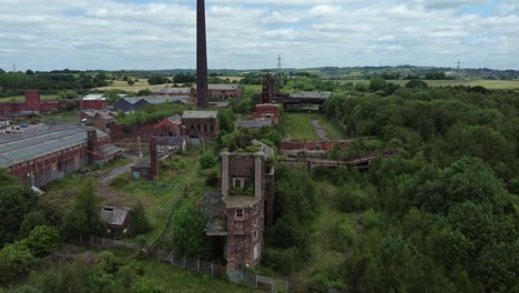 Abandoned-old-overgrown-coal-mine-industrial-museum-buildings-aerial-view-wide-orbit-right