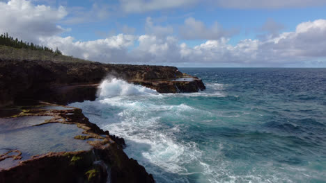 Aerial:-powerful-waves-crashing-against-cliffs,-Lifou-island-New-Caledonia