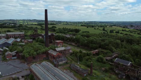 Abandoned-old-overgrown-rusting-coal-mine-industrial-museum-buildings-aerial-orbit-right-view
