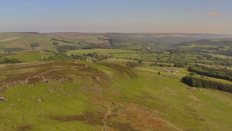 Beautiful-aerial-shot-flying-over-green-hills-in-the-Peak-District-in-England