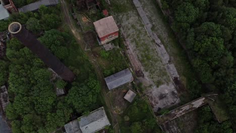 Abandoned-old-overgrown-coal-mine-industrial-museum-buildings-aerial-chimney-top-down-view
